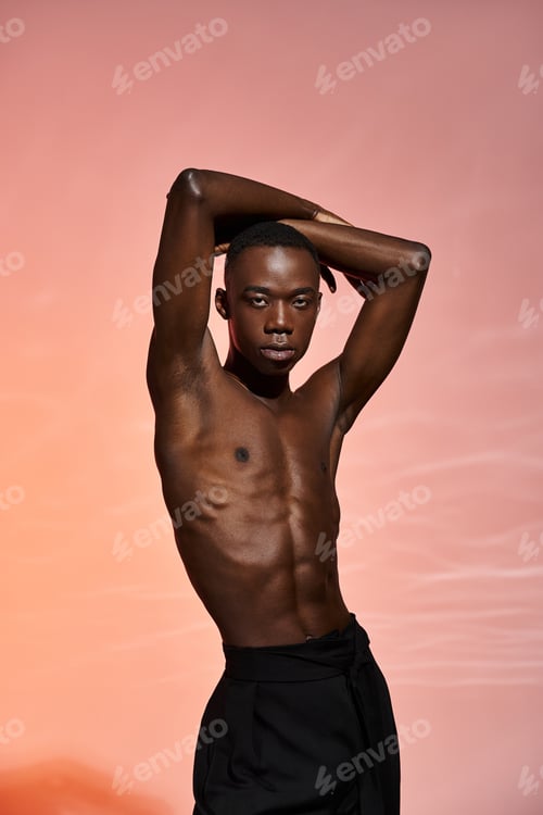 Preview: engaging shirtless african american man standing and looking at camera surrounded by red lights