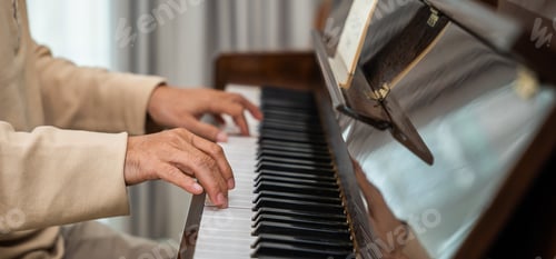 Preview: Asian senior retired man learning to play piano at home