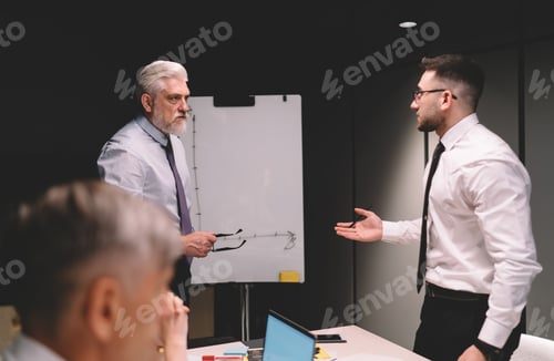 Preview: Senior businessman talking to male employee during meeting