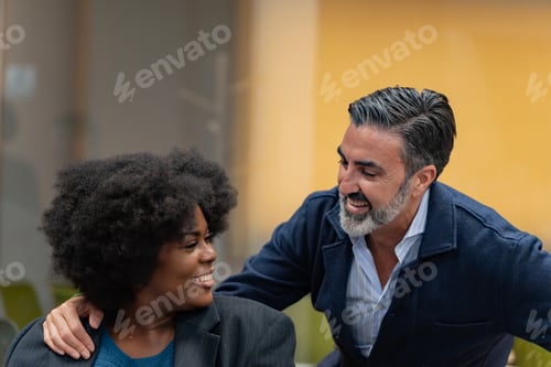 Preview: Laughing colleagues in a friendly office interaction.