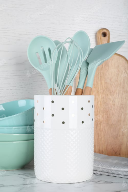 Preview: Holder with kitchen utensils, ceramic dishes and cutting board on white marble table