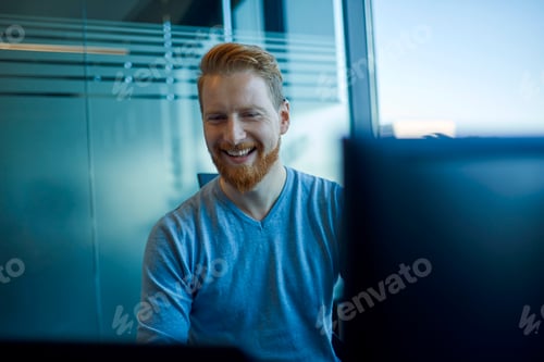 Preview: Happy businessman at desk in office