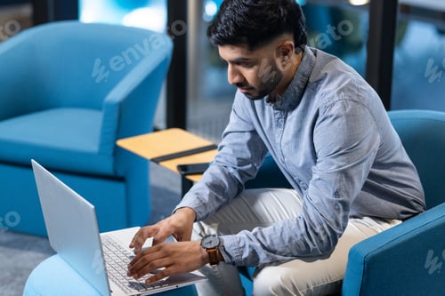 Preview: Typing on laptop, man working in modern office environment, focusing on task, copy space