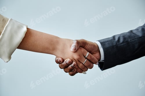 Preview: Minimal closeup of two business partners shaking hands in greeting against minimal white