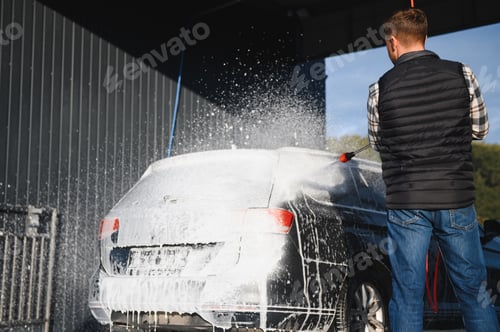 Preview: Car is washed at a professional car wash. Man washes a car with foam. Detailing