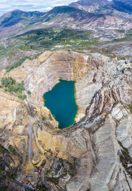 Preview: Vertical shot of a blue lake surrounded by mines in Queenstown, Tasmania, Australia