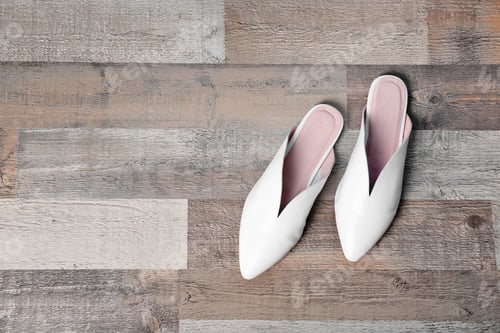 Preview: Pair of female shoes on wooden background, top view