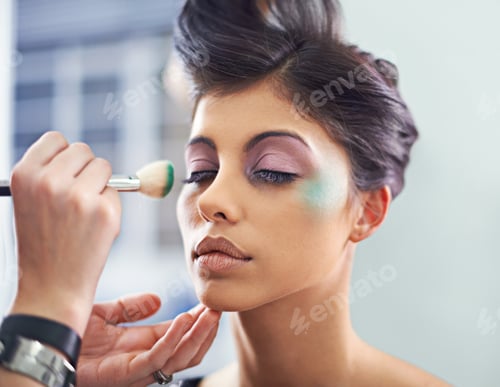 Preview: Creating a masterpiece. A young woman with cosmetic enhancements having makeup applied.