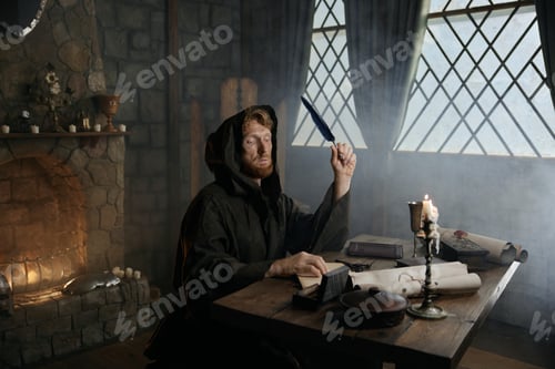 Preview: Medieval monk writing historic manuscripts at table