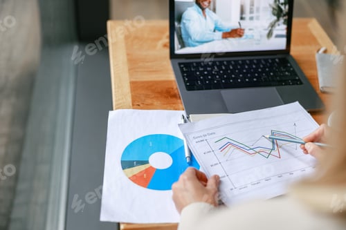 Preview: Close up of businesswoman making videoconference and demonstrate financial graphs to colleague