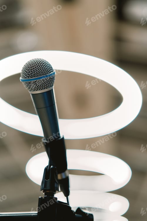 Preview: Microphone stands on a stand against the background of round lamps