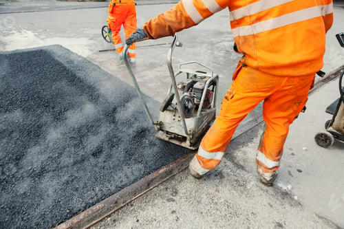Preview: Low section of manual worker laying asphalt at construction site