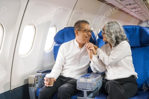 Preview: A mature couple enjoys a plane ride sitting near the window. They looked out into the sky