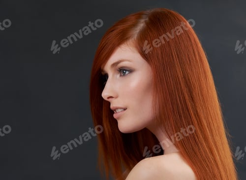 Preview: Scarlet stunner. Studio shot of a gorgeous young redheaded woman against a black background.