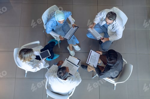 Preview: High angle view of diverse medical team discussing documents with each other in hospital
