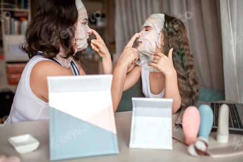 Preview: Girl and her mom watching beauty master class with tablets online and doing spa procedure at home