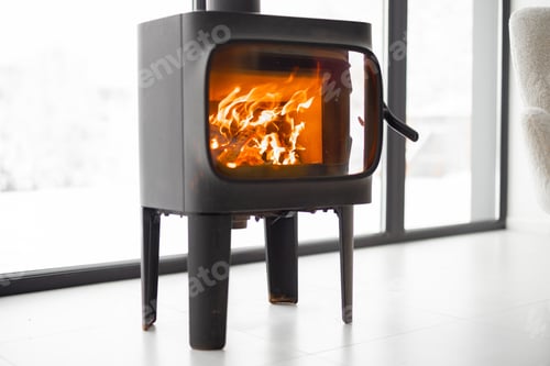 Preview: Cozy living space by the burning fireplace at snowy mountains