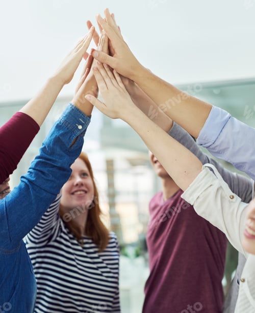 Preview: We work together as one. Shot of a group of people putting their hands up together.
