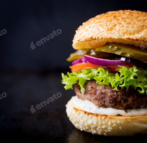 Preview: Big sandwich - hamburger burger with beef, pickles, tomato and tartar sauce on black background.