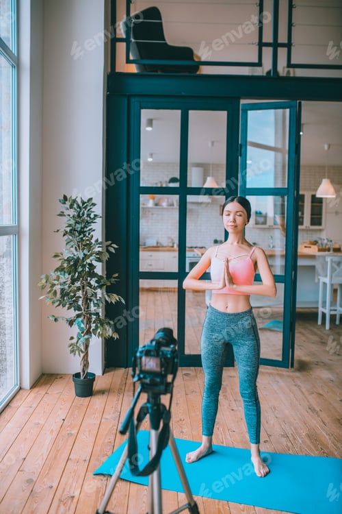 Preview: Fitness blogger filming yoga tutorial in the morning