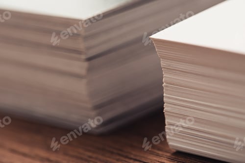Preview: selective focus of stacked business cards on brown wooden surface