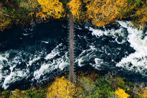 Preview: Aerial view of fall forest and blue river with bridge in Finland.