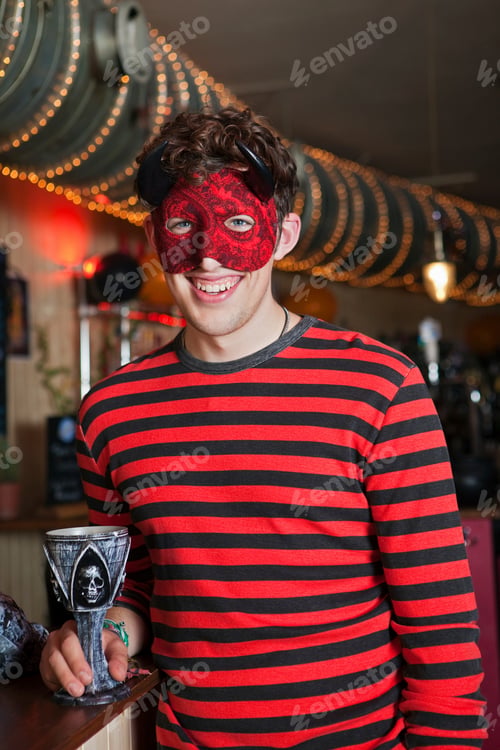 Preview: Young man in costume and mask in bar, portrait