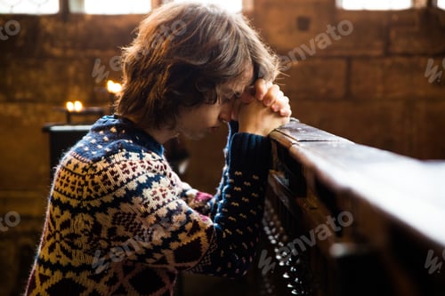 Preview: Young boy praying in a church