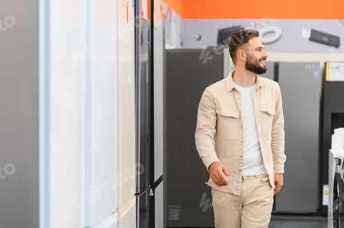 Preview: Customer choosing refrigerator in electronics store, smiling man walking through home appliance shop
