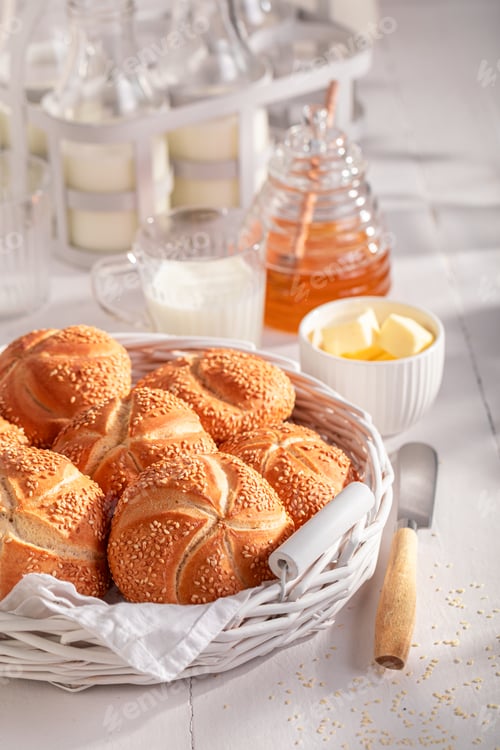 Preview: Sweet Kaiser rolls with sesame seeds in white basket.