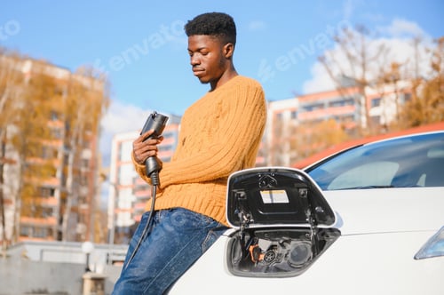 Preview: African American man charging his electric car.