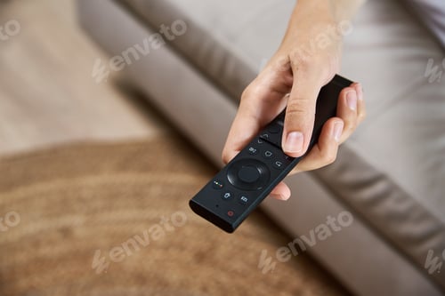 Preview: Woman switch TV set with remote control