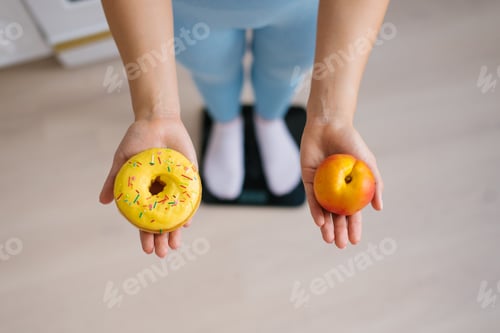 Preview: Woman making choice between peach fruit and donut
