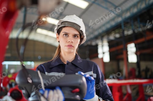 Preview: Robotics engineer working on maintenance of robotic arm in factory warehouse. Business technology.