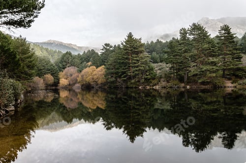 Preview: Reflections on water a misty day in the mountains