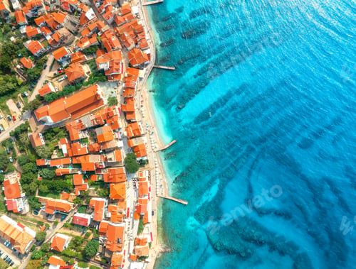 Preview: Aerial view of buildings with orange roofs, beach, blue sea