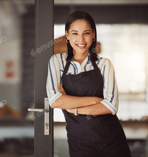 Preview: Beautiful businesswoman standing in her cafe entrance. Mixed race boss arms crossed in her coffeesh
