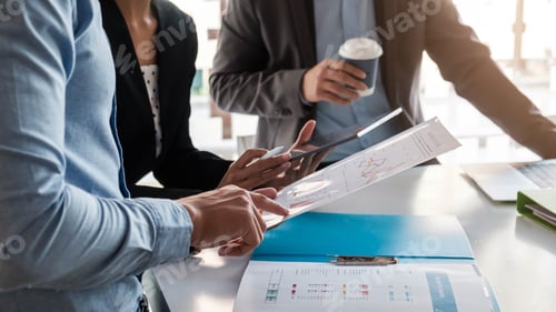 Preview: Businesswoman holding pens and holding graph paper are meeting to plan sales to meet targets set in