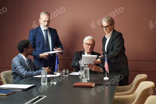 Preview: Diverse Group of Middle Aged Politicians Discussing Documents during Meeting