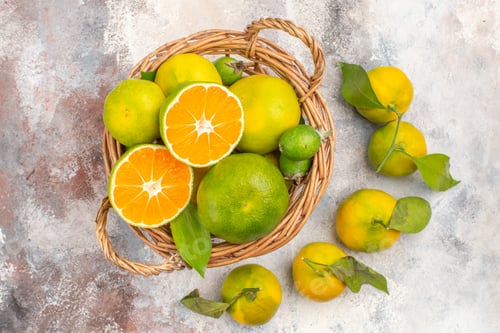 Preview: top view fresh mandarines in wicker basket surrounded by mandarines on nude background
