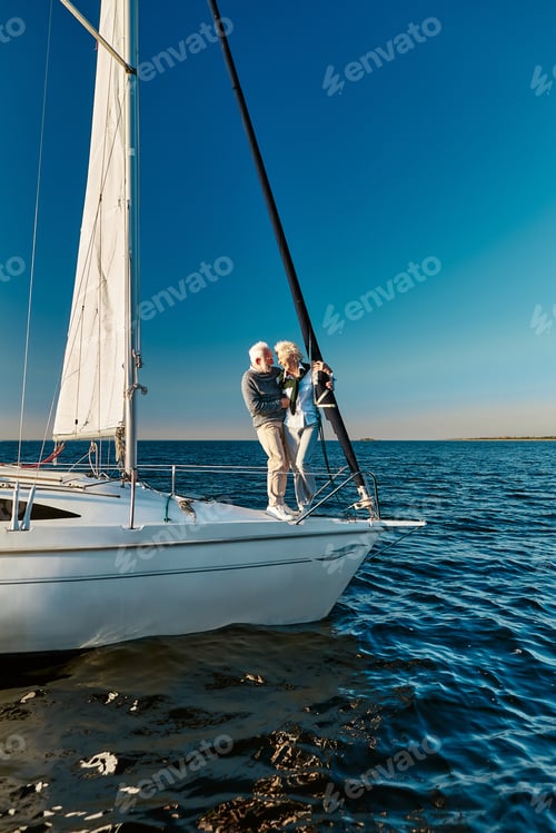 Preview: Full length of beautiful senior couple in love travelling by sea, they are standing on