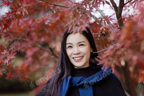 Preview: Candid portrait of beautiful Young stylish asian woman relaxing in park outdoor at Autumn