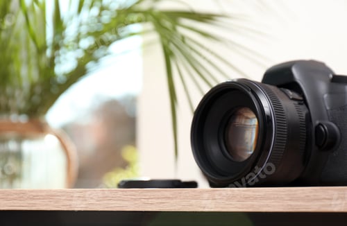 Preview: Professional camera on table against blurred background, space for text. Photographer's equipment