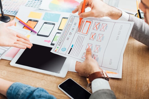 Preview: Selective focus of designers developing ux design of website near gadgets on table