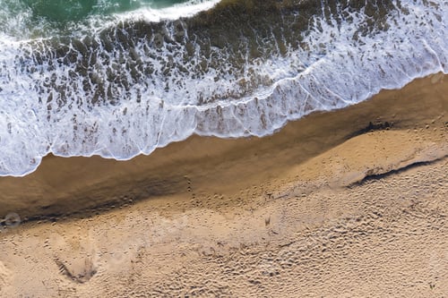 Preview: Aerial View of Ocean Waves Washing a Secluded Sandy Shoreline Beach
