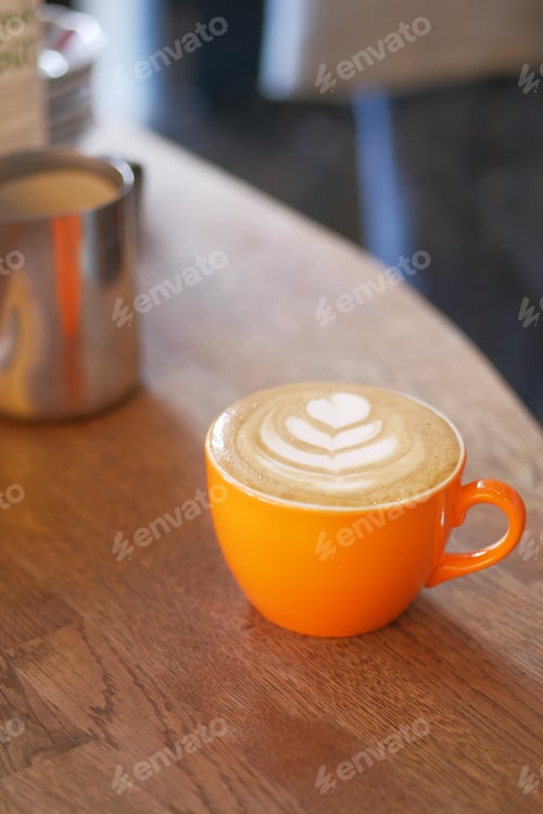 Preview: Latte Art in Orange Cup on Wooden Table