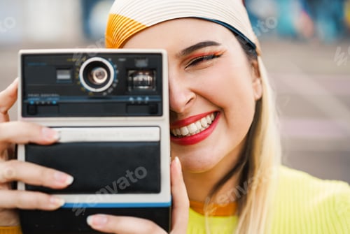 Preview: Young trendy woman using vintage old instant photo camera outdoor