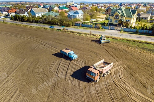Preview: Aerial view of a tractor plowing black agriculture farm field after harvesting in autumn.