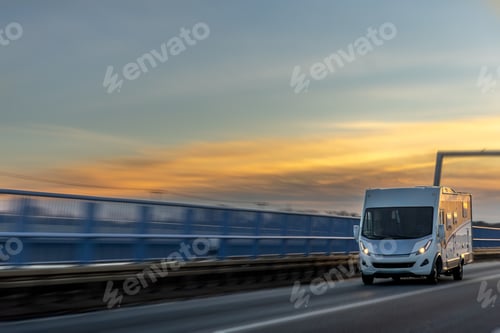 Preview: Motorhome races across bridge at sunset. Dream roadtrip.