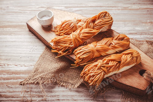 Preview: Smoked braided cheese, chechil cheese on wooden cutting board